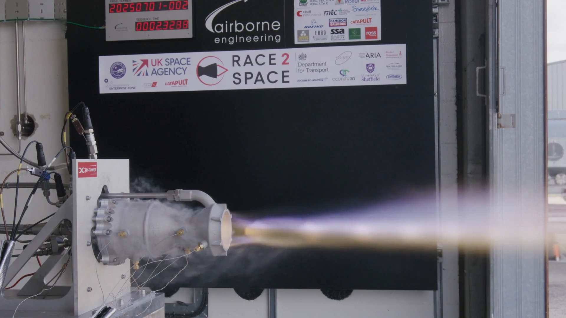 Cell camera view of the burn: a yellow ignition plume turns purple, then a fireball, then the engine shuts down