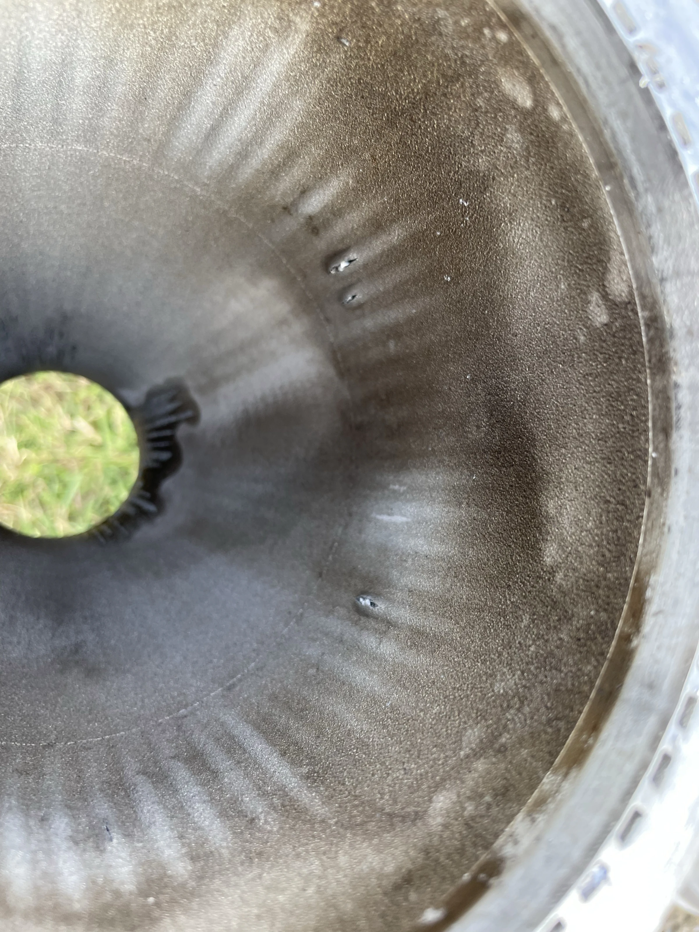 Looking up the nozzle at ruptured cooling channels with metal swarf spilling from the openings