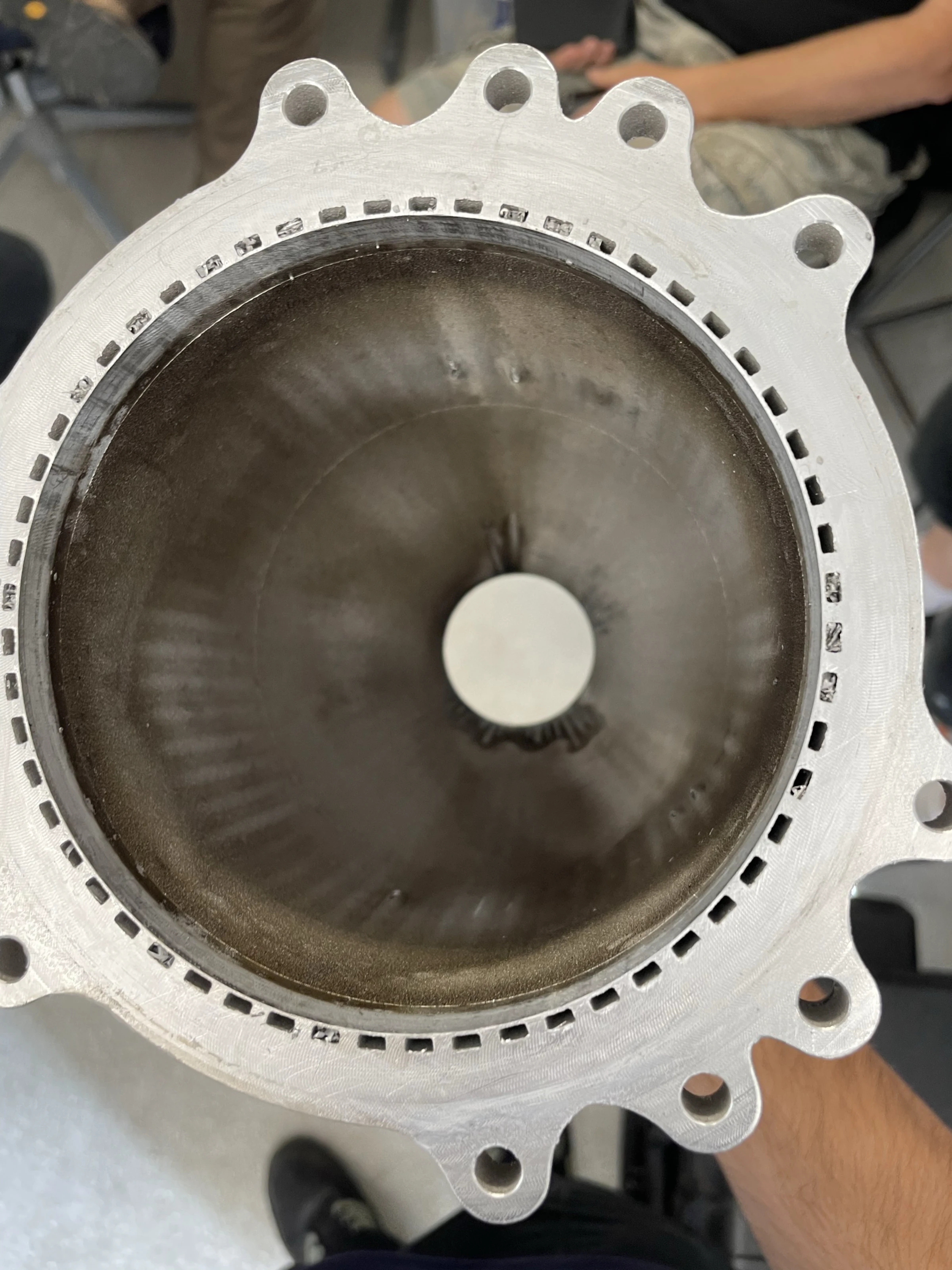 View down the chamber bore from the injector end showing bulged and popped channels and melt streaks at the throat