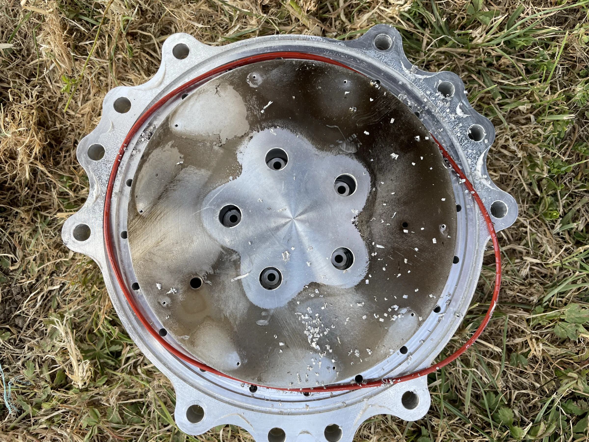 Injector plate just removed from the chamber, its face covered in metal swarf