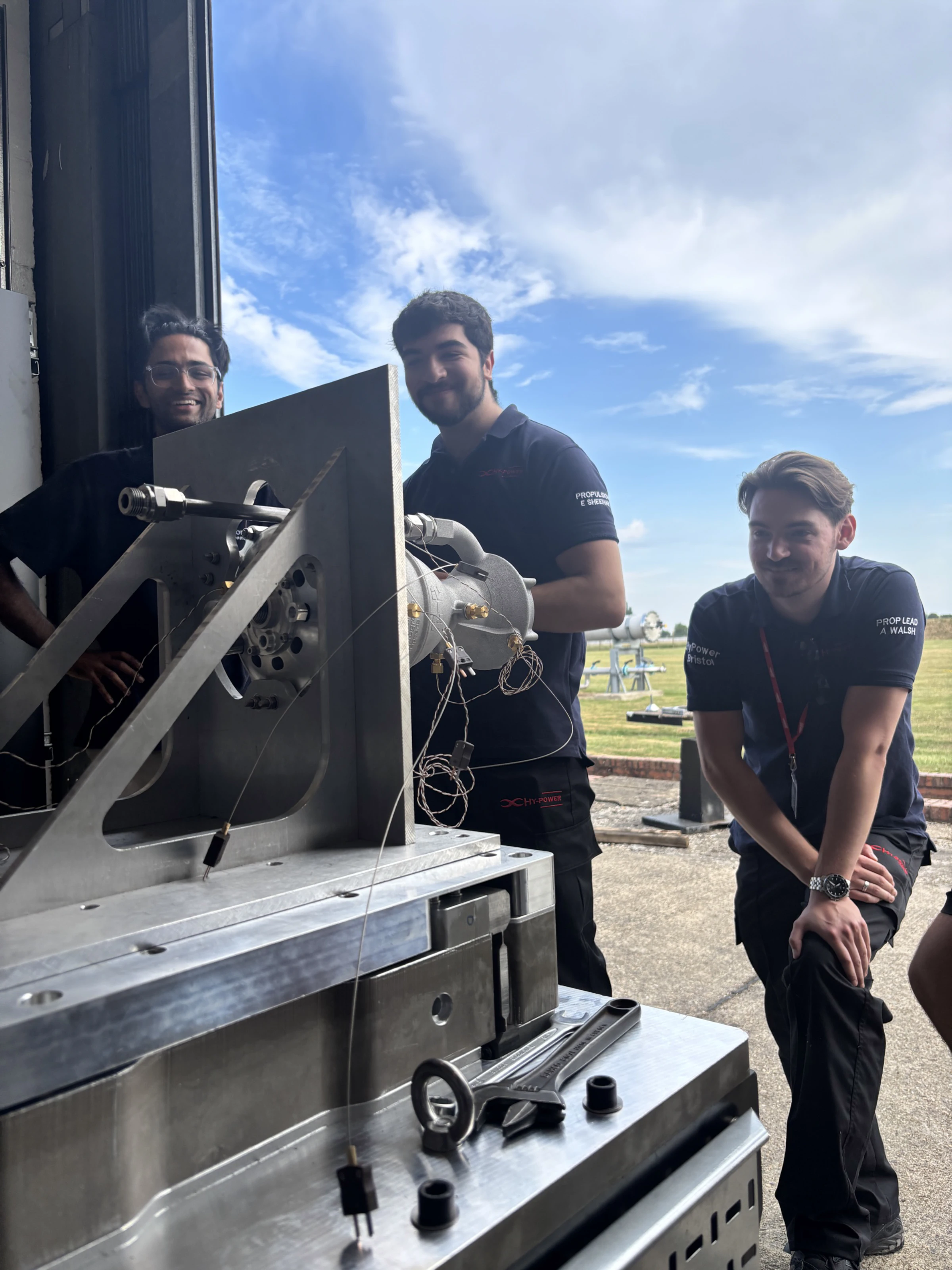 Team members lifting the engine into position on the test stand