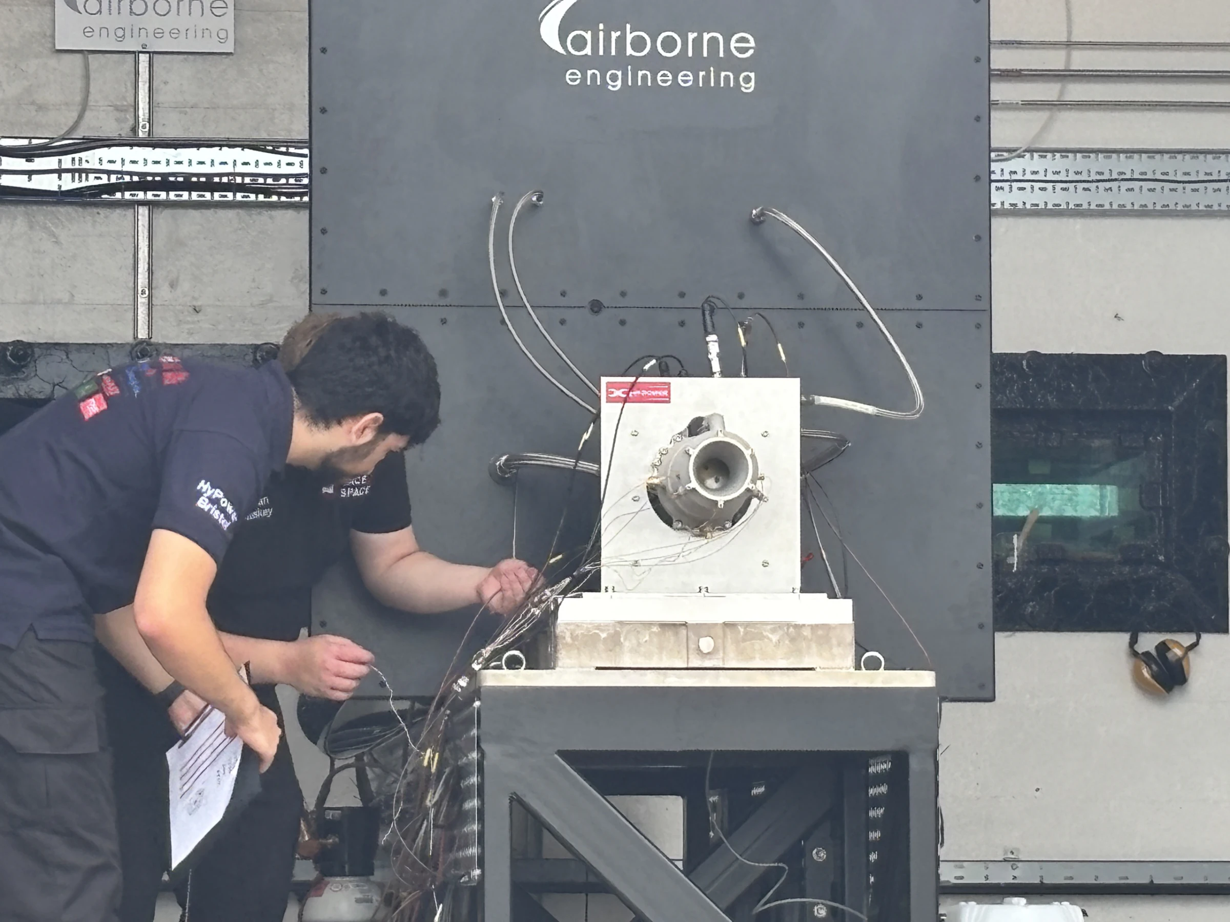 Wide view of the test cell with thermocouple wiring running to the engine on the stand
