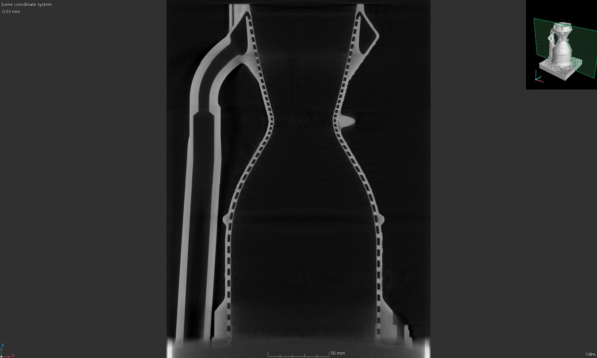 Single X-ray CT vertical section at the chamber centreline showing the hourglass profile with channel voids dashed along both walls