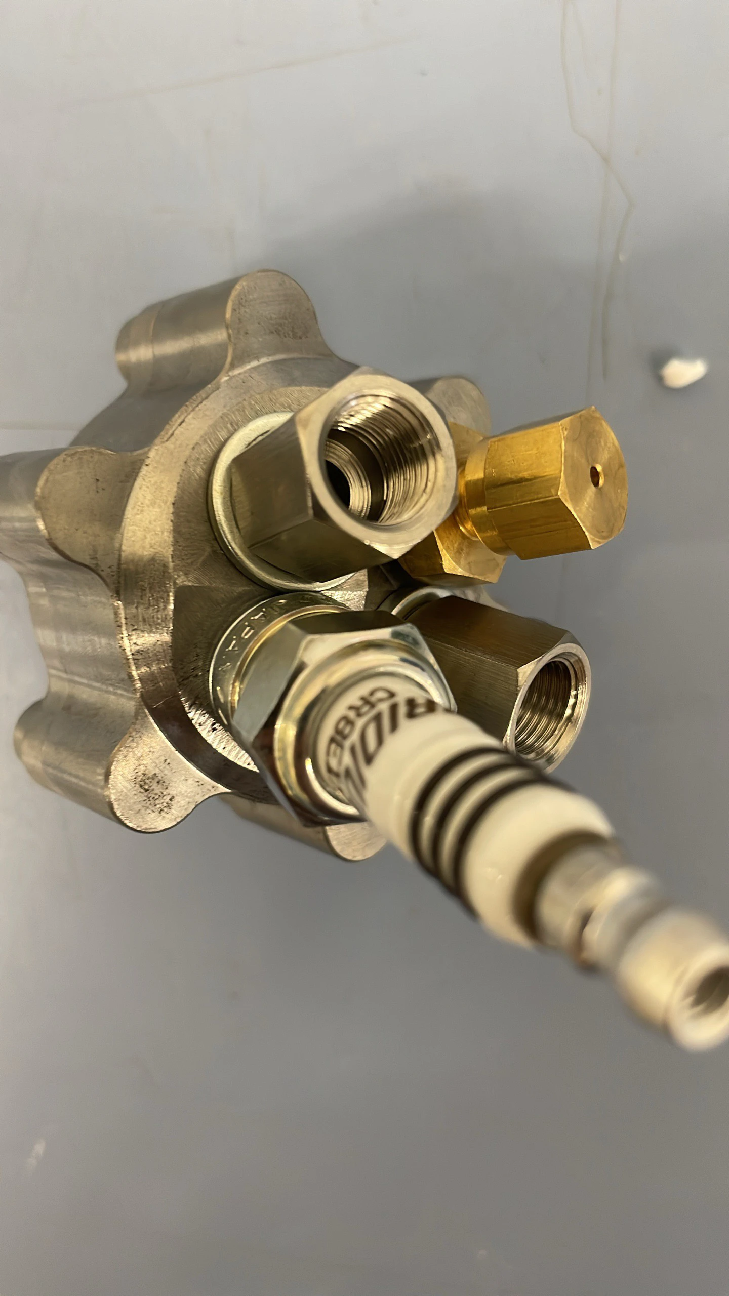 Close view of the assembled igniter with its two brass inlet fittings and spark plug.