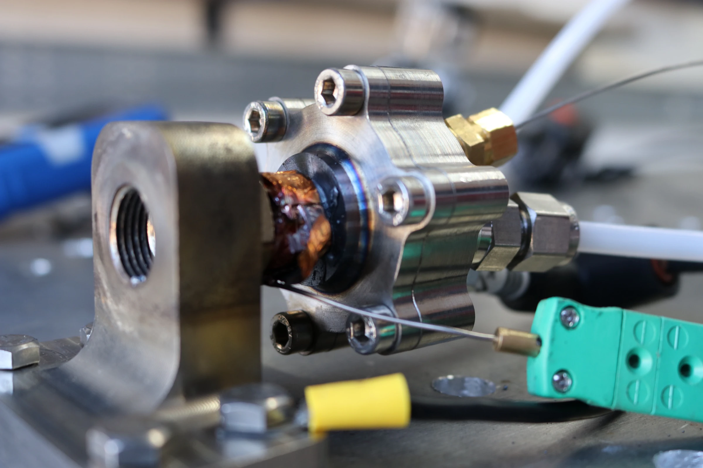 Side view of the mounted igniter between firings, scorch marks and orange discolouration spreading around the copper gasket.