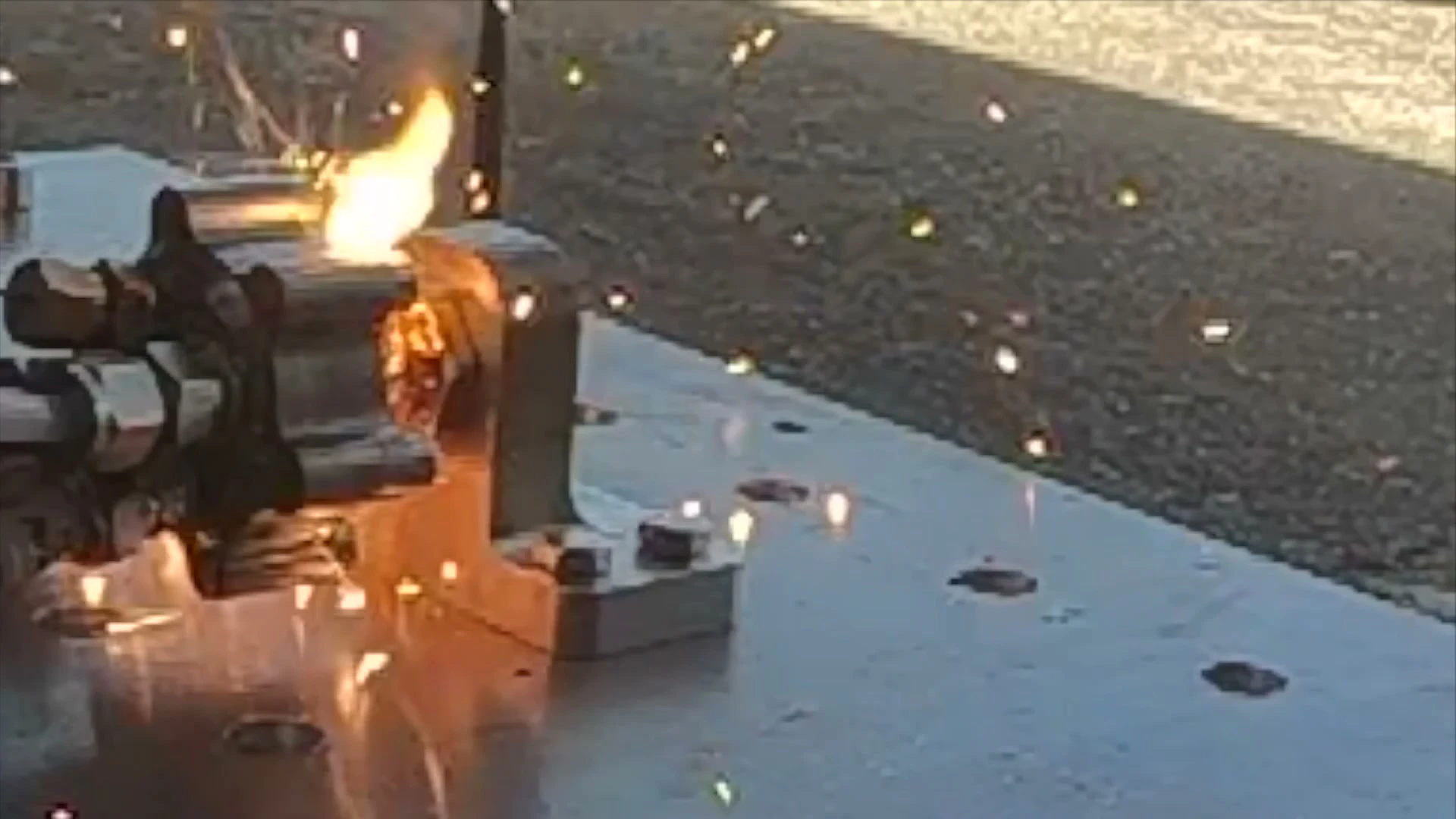 GoPro frame of the igniter on the test plate with a jet of flame torching sideways out of the body wall.
