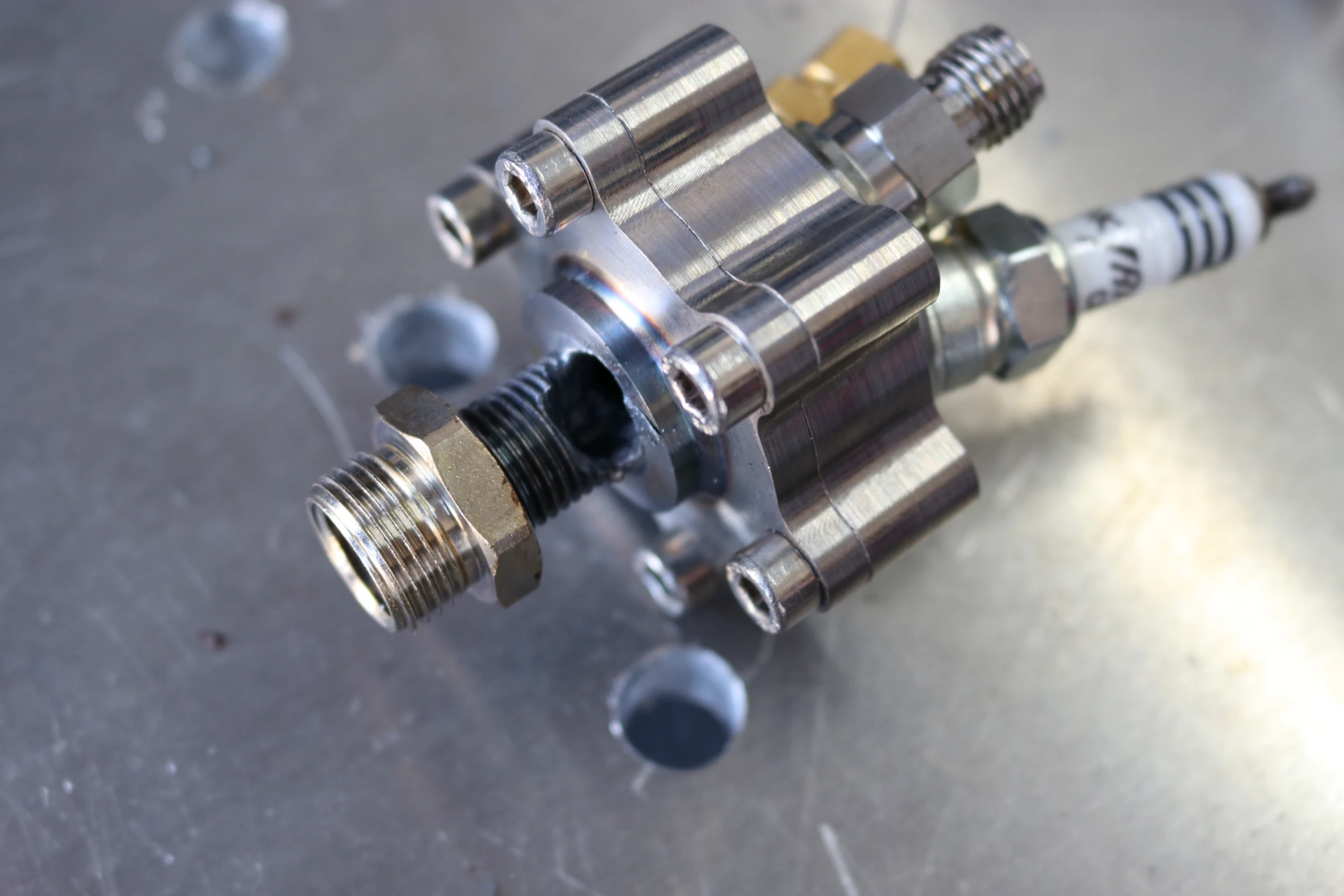 The igniter off the stand on a bench, heavily sooted but intact, spark plug still fitted.