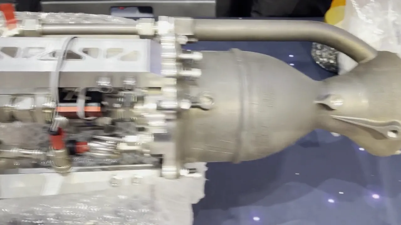 Handheld pan along the flight propulsion system on the bench: the printed chamber and bell nozzle, the injector and valve block with its feed lines and pressure transducers, then the white tank sections and their bulkhead plumbing