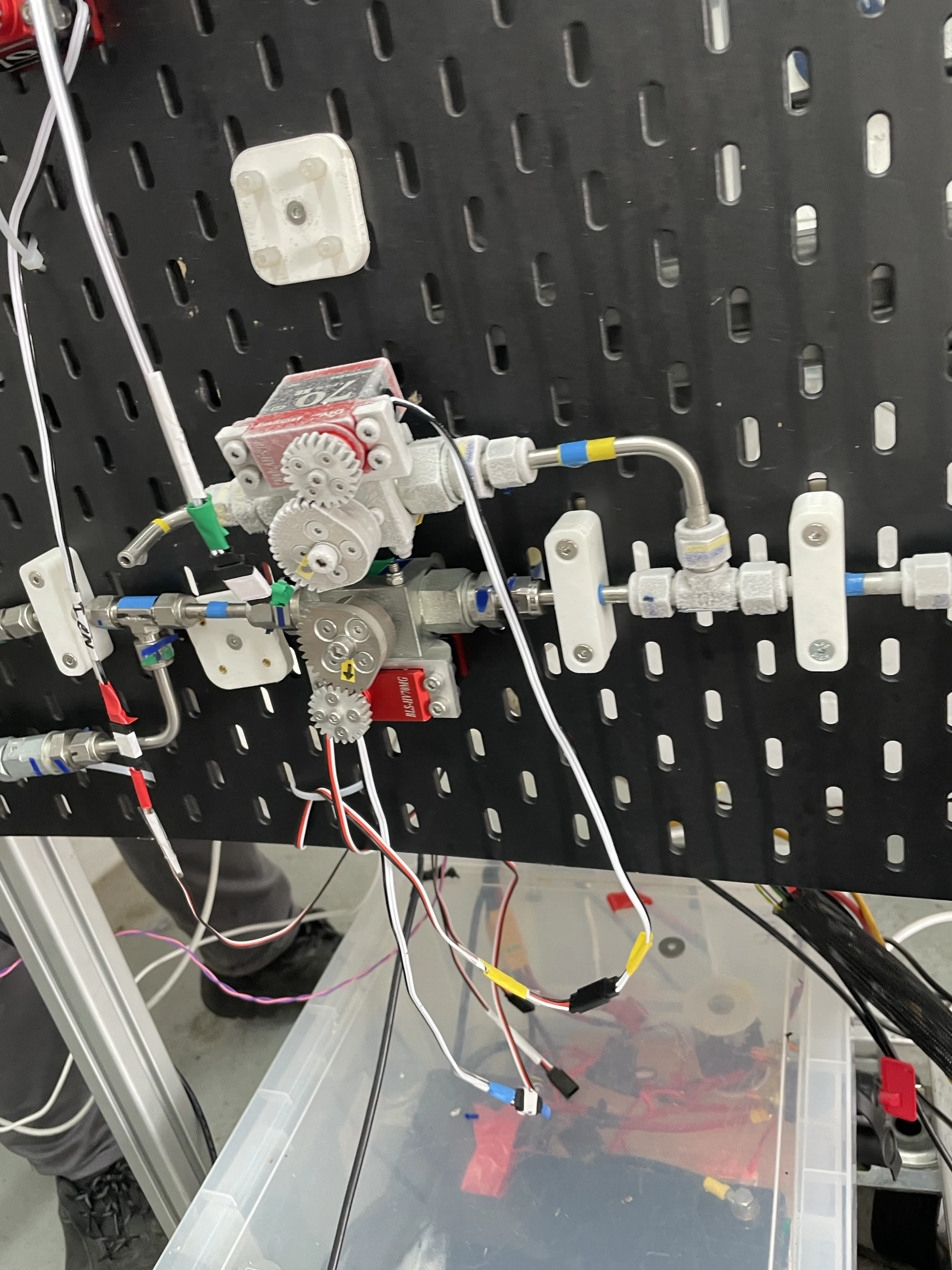 Close on the run panel in the bay: solenoid valves, fittings and colour-coded wiring on a black perforated board