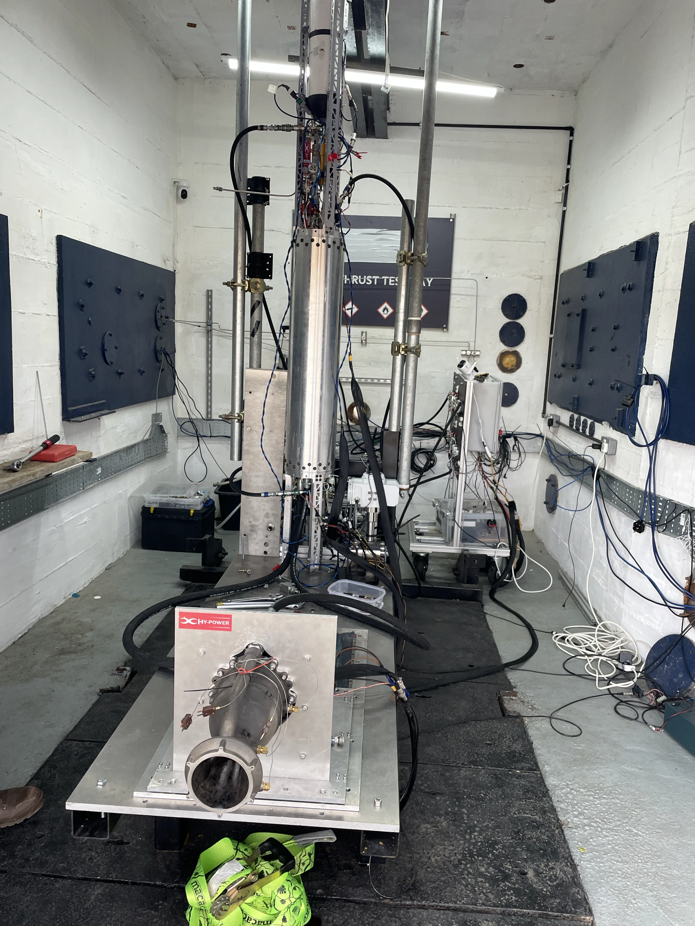 The same stack from closer in, the engine's nozzle pointing at the camera and the tank's feed lines and instrumentation running up the bay wall