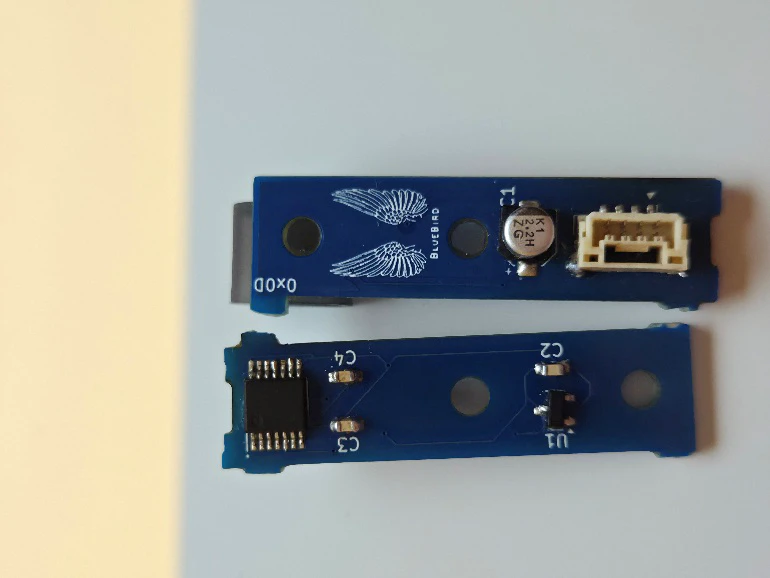 Two blue angle-sensor circuit boards on a white surface, one face up with the BlueBird winged logo and a JST connector, one face down showing the Hall-effect chip and passives