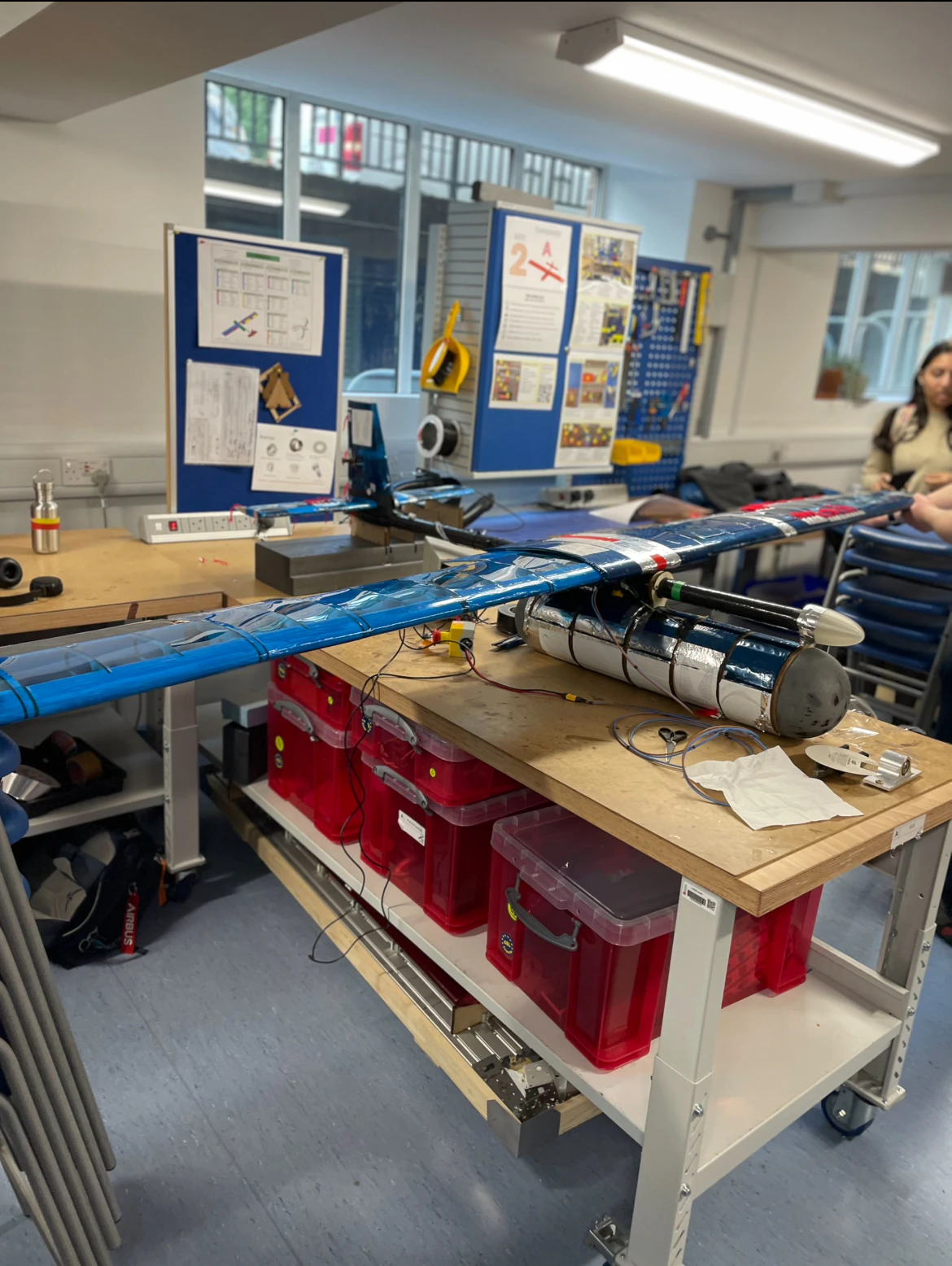 The assembled aircraft from the nose, wing sweeping away to both sides above the red parts boxes