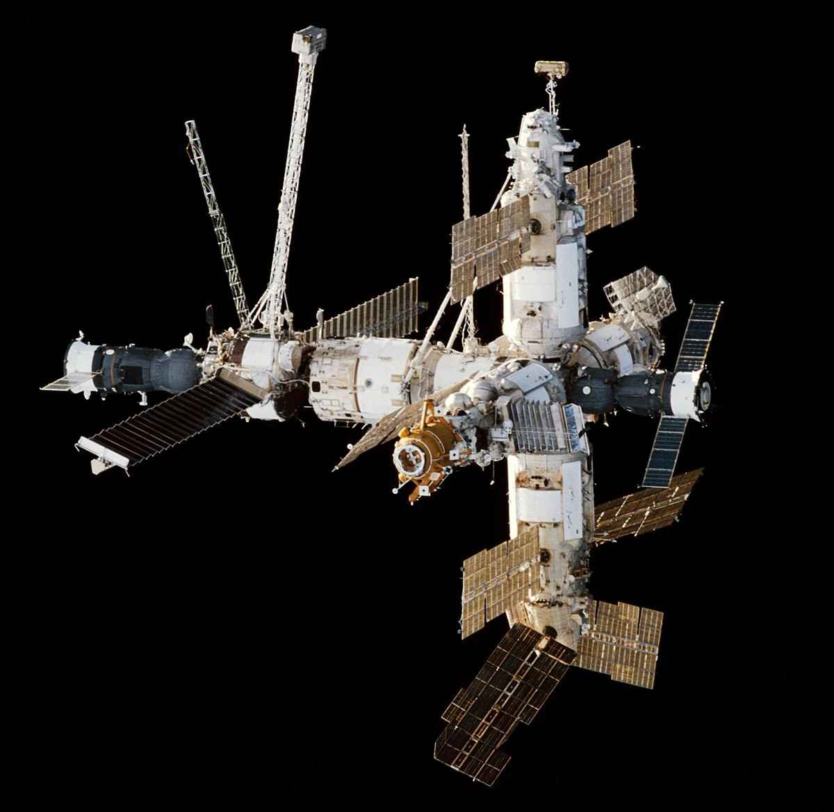 The Mir space station photographed from Atlantis against black space, modules and solar arrays extended